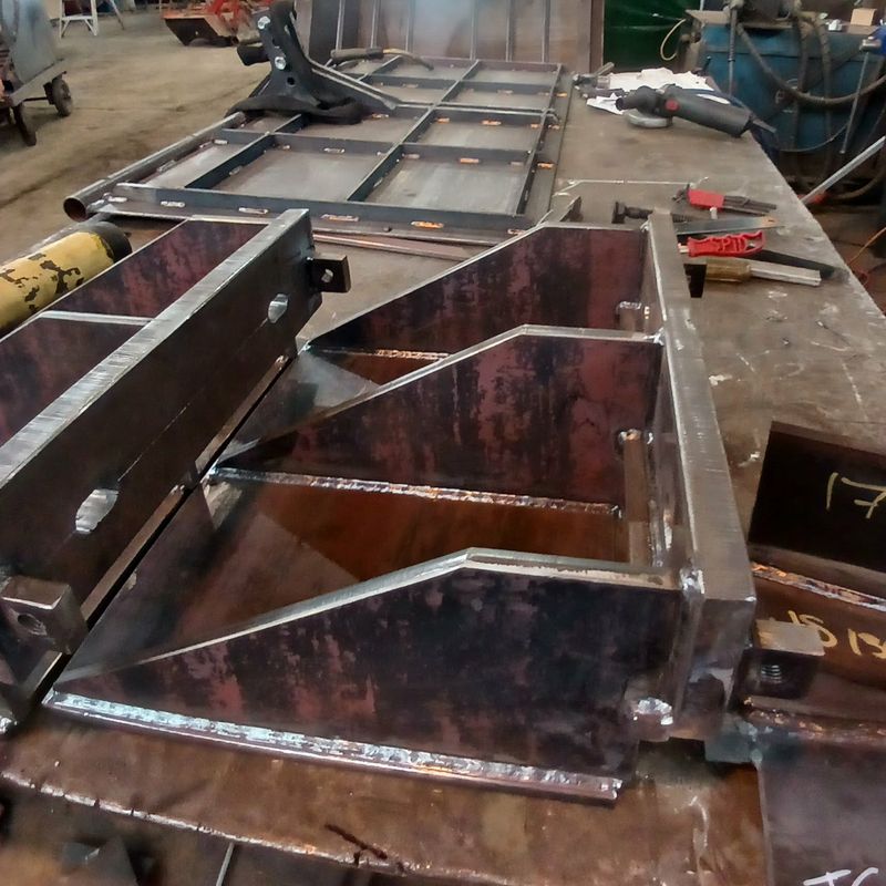 Custom fabricated steel hoppers on the workbench